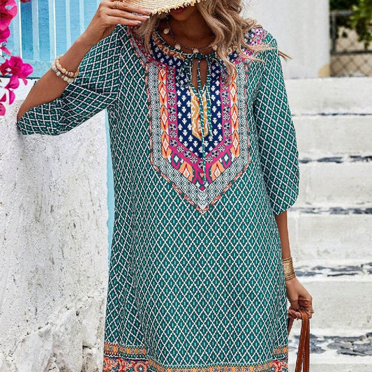 Blue geometric print casual dress with colorful embroidered neckline and three-quarter sleeves.