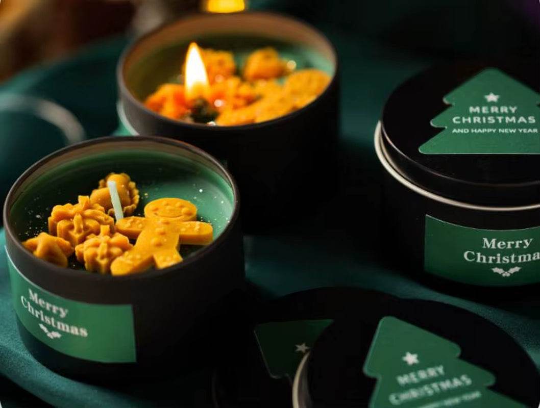 Green soy wax candle in black tin with gingerbread-shaped wax decorations and "Merry Christmas" label.