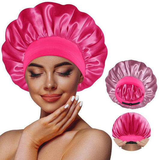 Reversible satin sleep bonnet in hot pink and dark rose gold with elastic band modeled on woman.