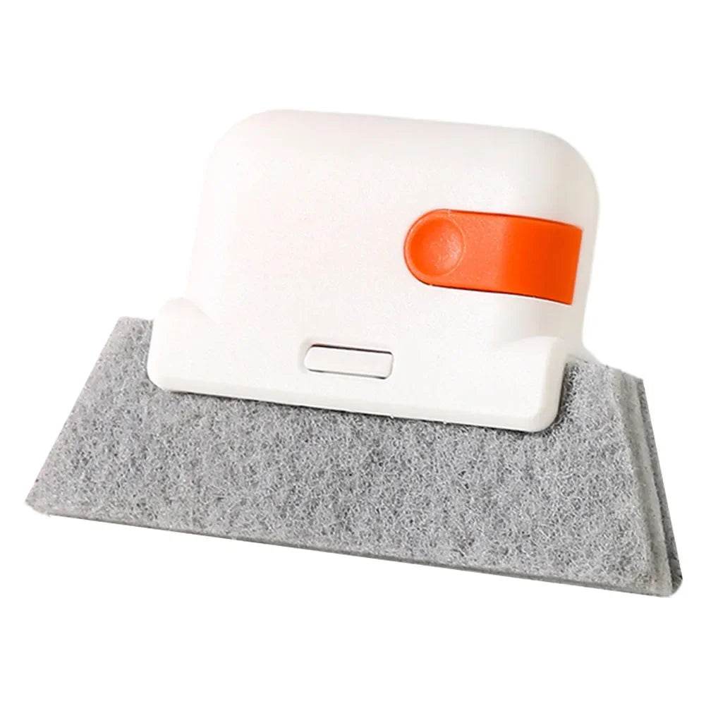 White and orange handheld groove cleaning brush with gray felt pad for window and door tracks.