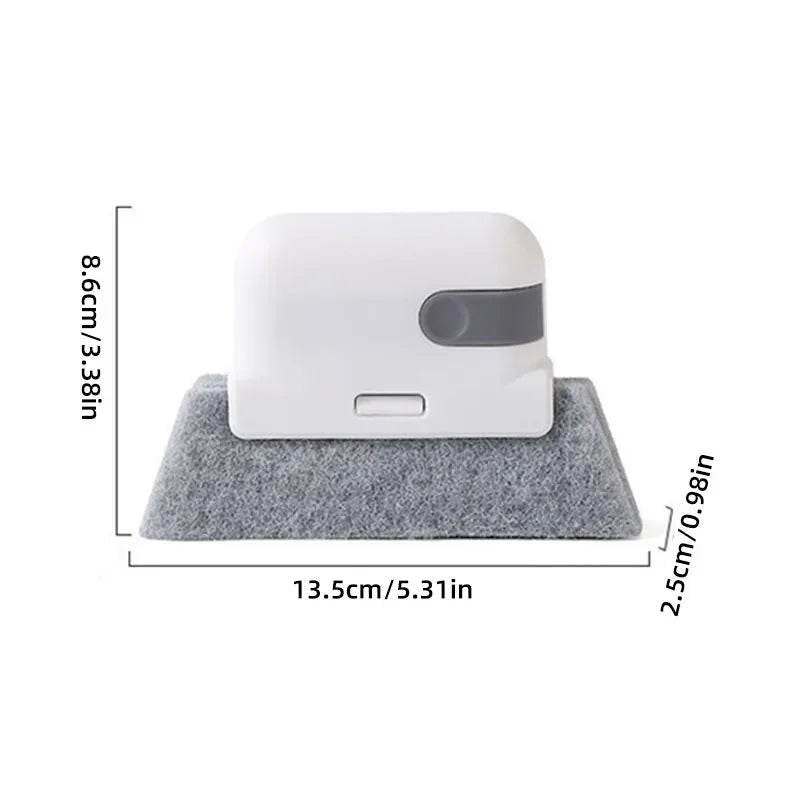 Compact white handheld groove cleaning brush with gray microfiber base, 13.5 cm wide and 8.6 cm tall.