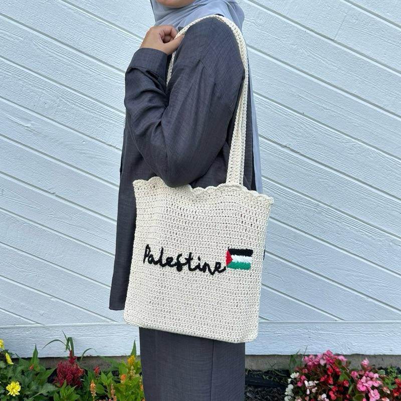 Cream handmade crochet tote bag with "Palestine" embroidered in black and a small Palestinian flag on the front.