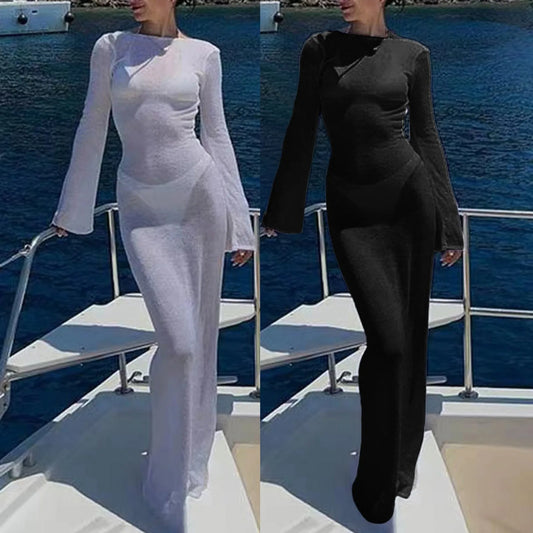 Two women on a boat, one in a white dress and the other in a black outfit, with water in the background.