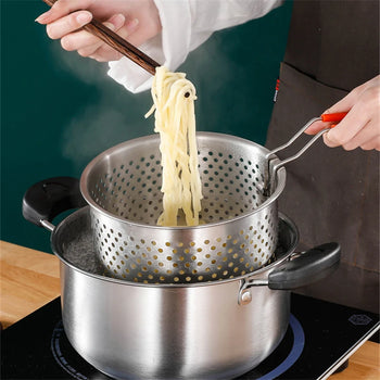 Person using a perforated metal colander to drain pasta over a pot on a stove.
