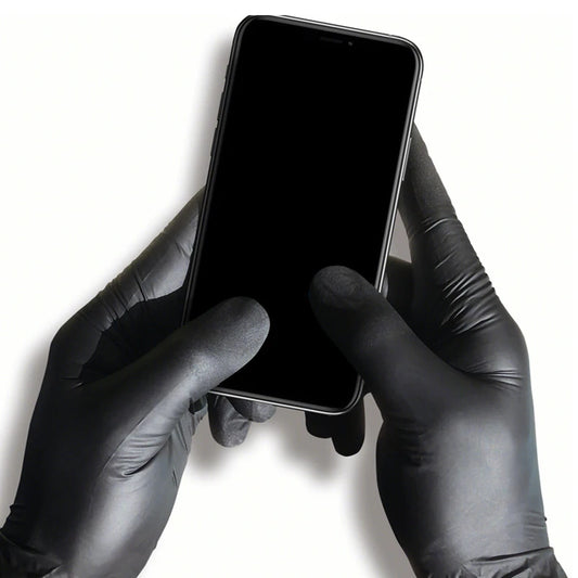 Hands wearing black gloves holding a smartphone on a white background
