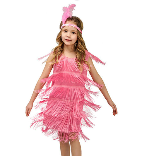Young girl wearing a pink fringe dress with feather headband on a white background