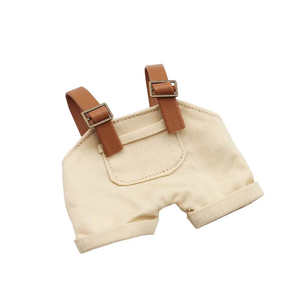 Beige cotton mini doll overalls with brown adjustable straps and front pocket detail.