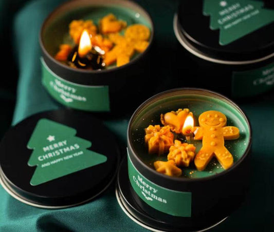 Green tin candle with vanilla scent featuring lit wick and gingerbread-shaped soy wax decorations.