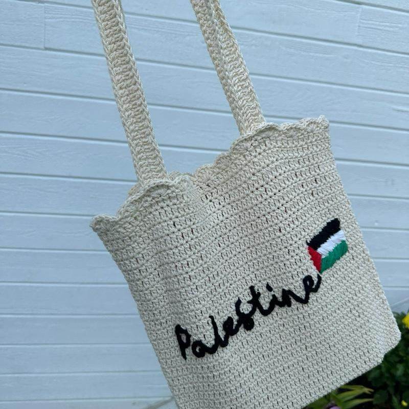 Beige handmade crochet tote bag with "Palestine" script and flag embroidery, long handles.