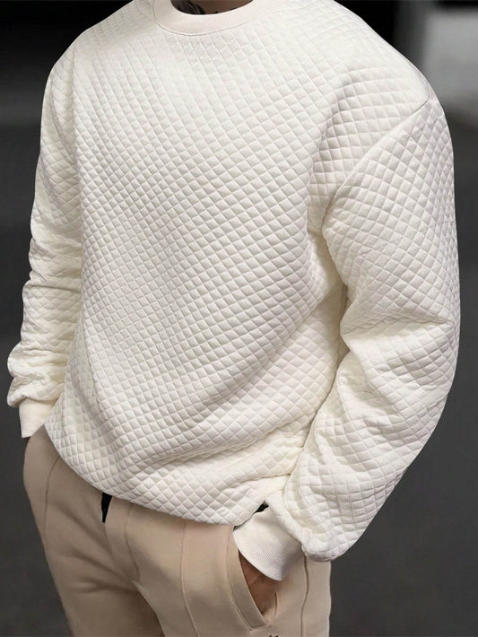 Apricot quilted long sleeve sweatshirt with drop shoulders and ribbed cuffs on a male model.