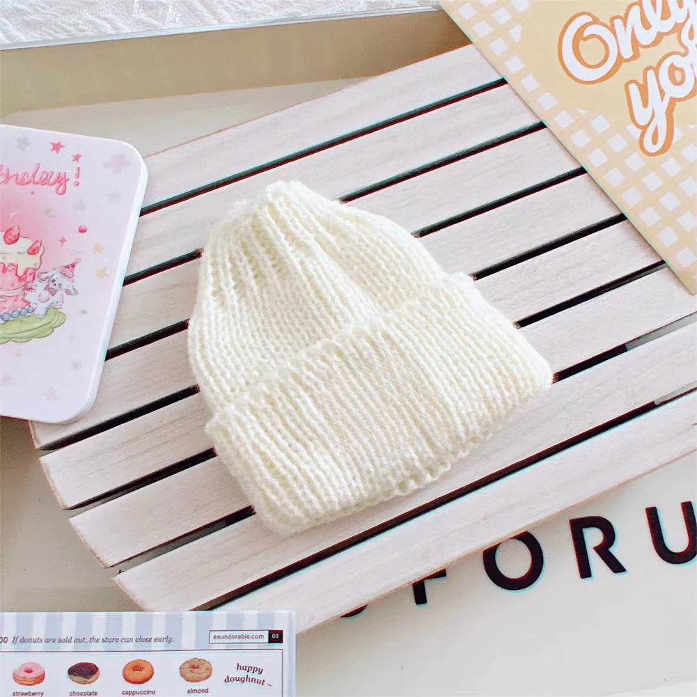 Cream-colored knitted beanie hat for 17cm mini dolls with ribbed texture.