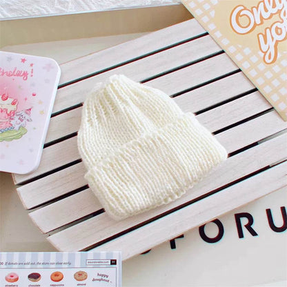 Cream-colored knitted beanie hat for 17cm mini dolls with ribbed texture.
