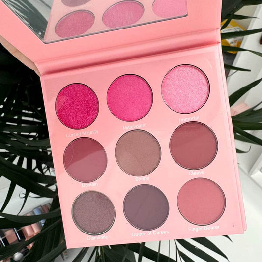 Pink eyeshadow palette with nine matte and shimmer shades ranging from bright pink to mauve and brown tones.