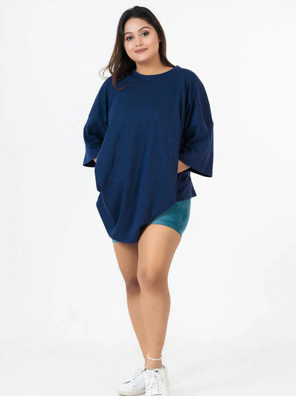 Navy blue relaxed fit T-shirt with dropped shoulders worn with teal shorts and white sneakers.