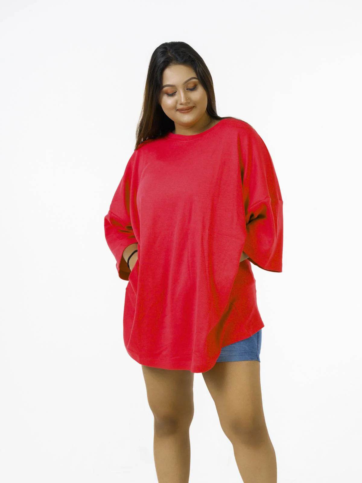 Relaxed fit bright red oversized t-shirt with short sleeves worn with denim shorts.