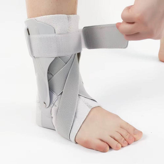 Light gray ankle foot orthosis with adjustable straps worn on a bare foot for support and stabilization.