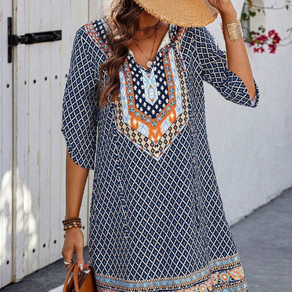 Blue casual dress with geometric and tribal-inspired prints, three-quarter sleeves, and V-neckline with button details.