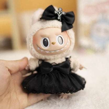 17cm doll wearing a fluffy cream hood with a black bow and a black devil-themed dress with a tulle skirt.