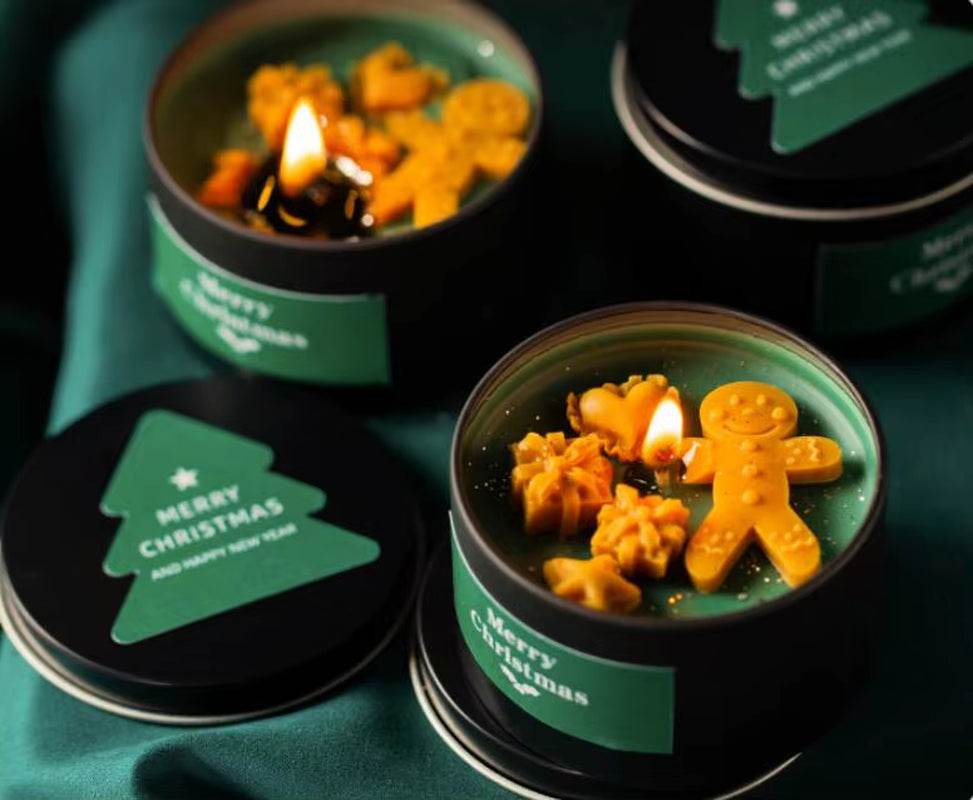 Green soy wax candle in a tin with vanilla scent and decorative gingerbread-shaped wax charms.