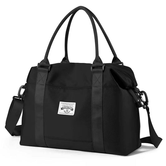 Black waterproof duffel bag with dual handles, detachable shoulder strap, and front patch logo.