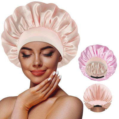 Reversible satin sleeping bonnet in soft pink with elastic band, worn by woman with smooth skin and manicured nails, plus.