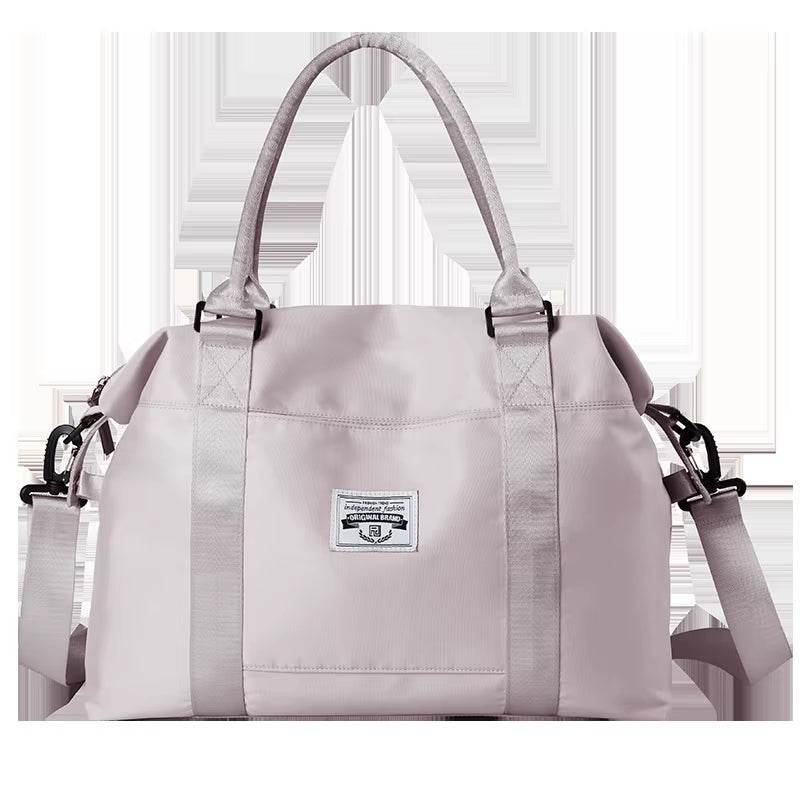 Light purple waterproof duffel bag with dual top handles, front logo patch, and detachable shoulder strap.