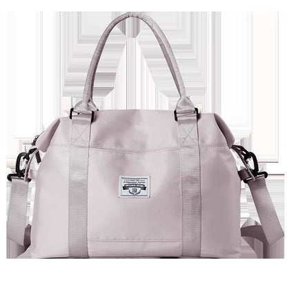 Light purple waterproof duffel bag with dual top handles, front logo patch, and detachable shoulder strap.