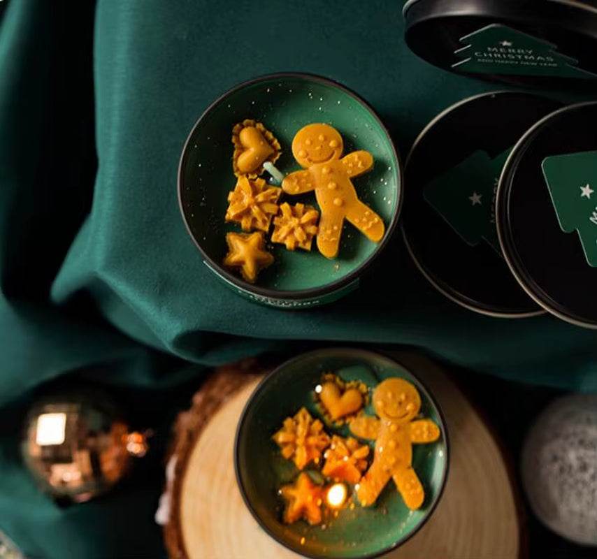Green soy wax candle in a round tin with vanilla scent, decorated with gingerbread and star shapes.