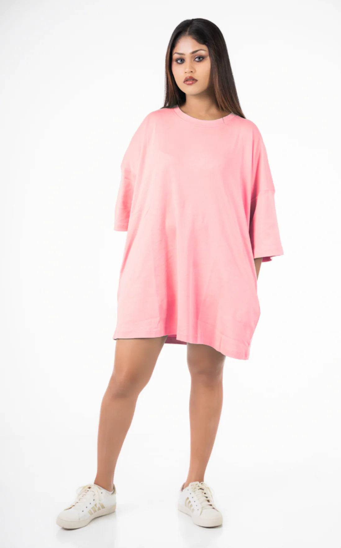 Light pink relaxed fit oversized t-shirt with three-quarter sleeves and crew neck, worn with white sneakers.