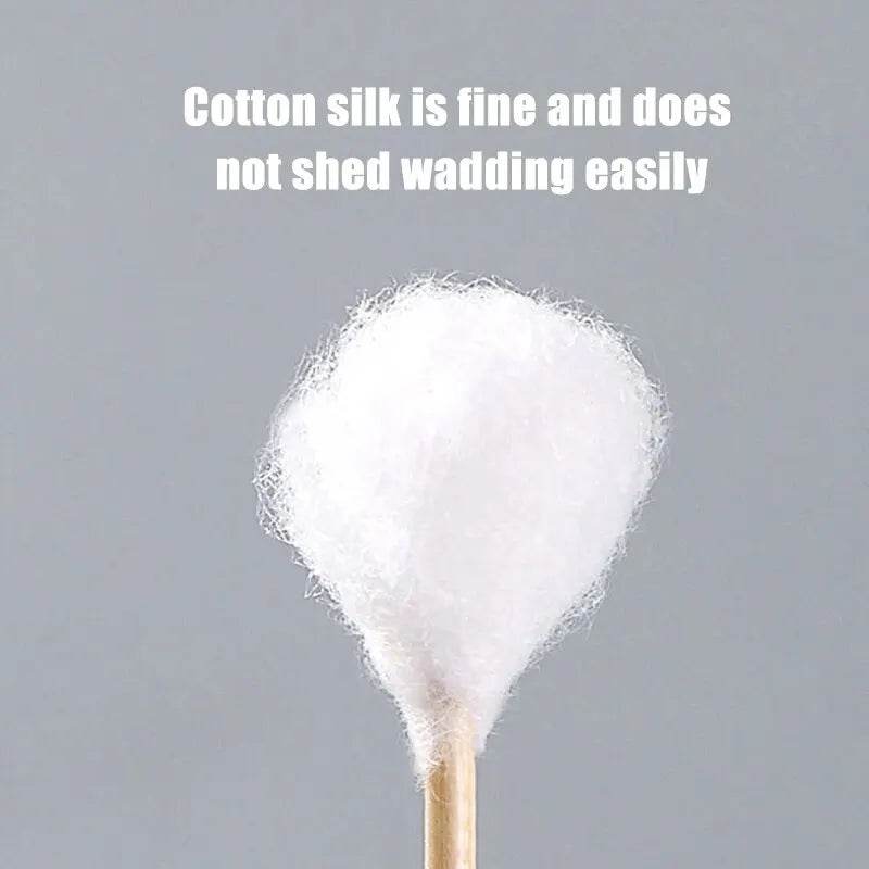 Close-up of a single white cotton swab with a rounded double-ended tip on a gray background.