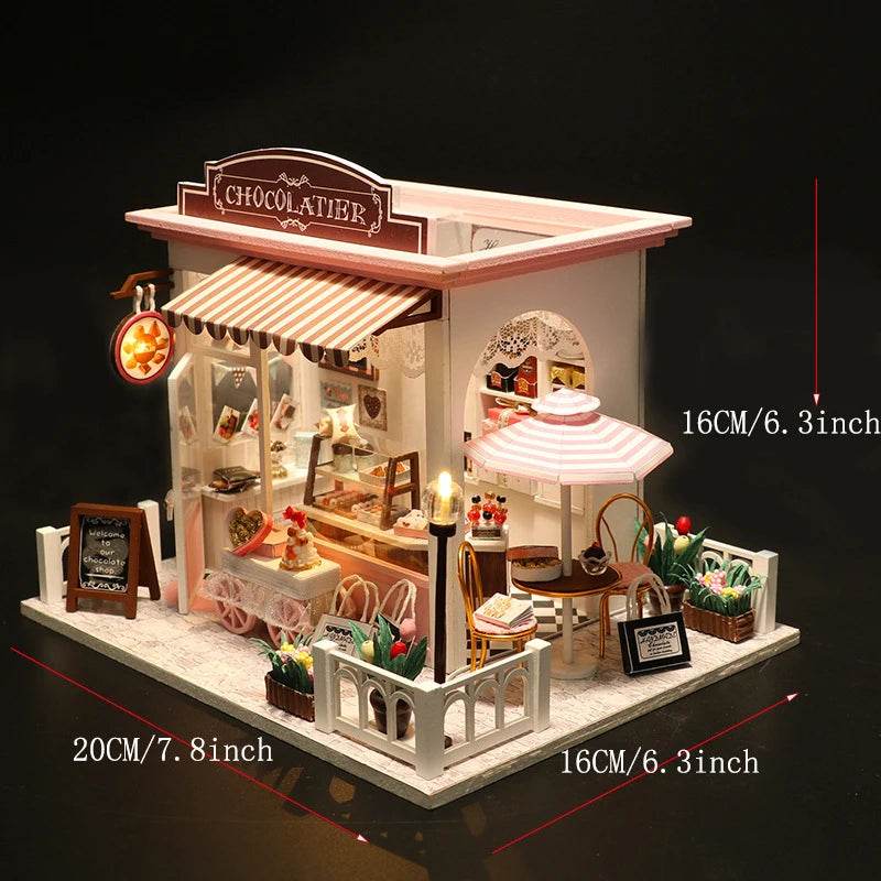 Miniature 3D flower shop dollhouse with outdoor seating, striped awning, and white picket fence.