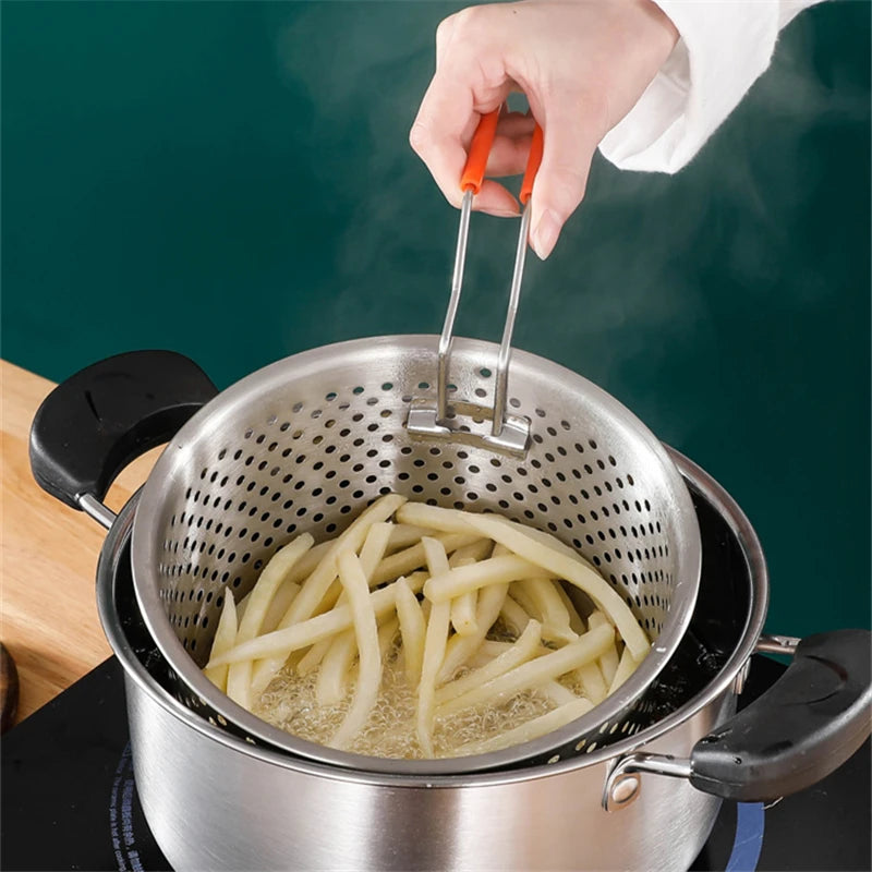 Person frying french fries in a deep fryer with a strainer.