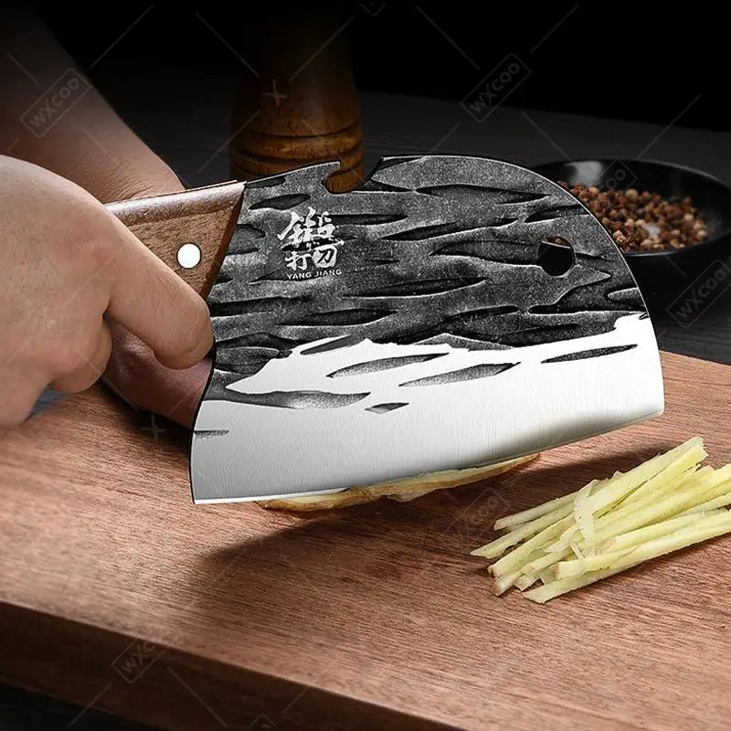 Person using a cleaver to chop ginger on a wooden cutting board with a dark background.