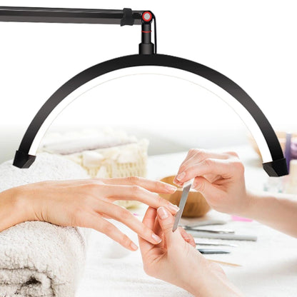 Person getting a manicure with a nail lamp illuminating the hands.