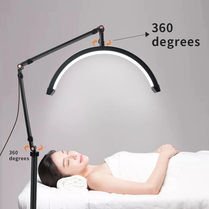 LED lamp with adjustable arm over a person receiving a treatment, on a gray background.