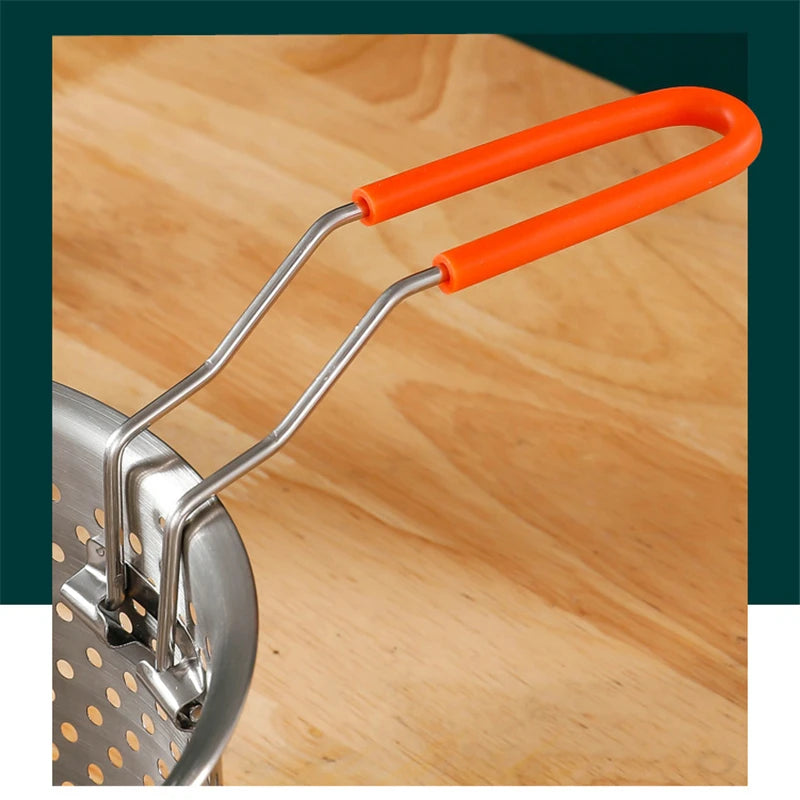 Metal pasta press with orange handles on a wooden surface