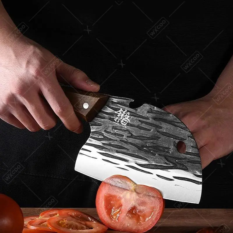 Person holding a cleaver with a wavy blade over sliced tomatoes on a dark background