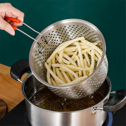 Frying french fries in a pot with a metal strainer.