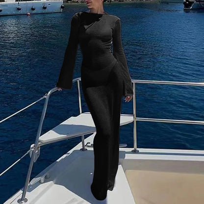 Person in a black outfit standing on a boat with water in the background