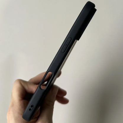 Hand holding a black smartphone with a plain background