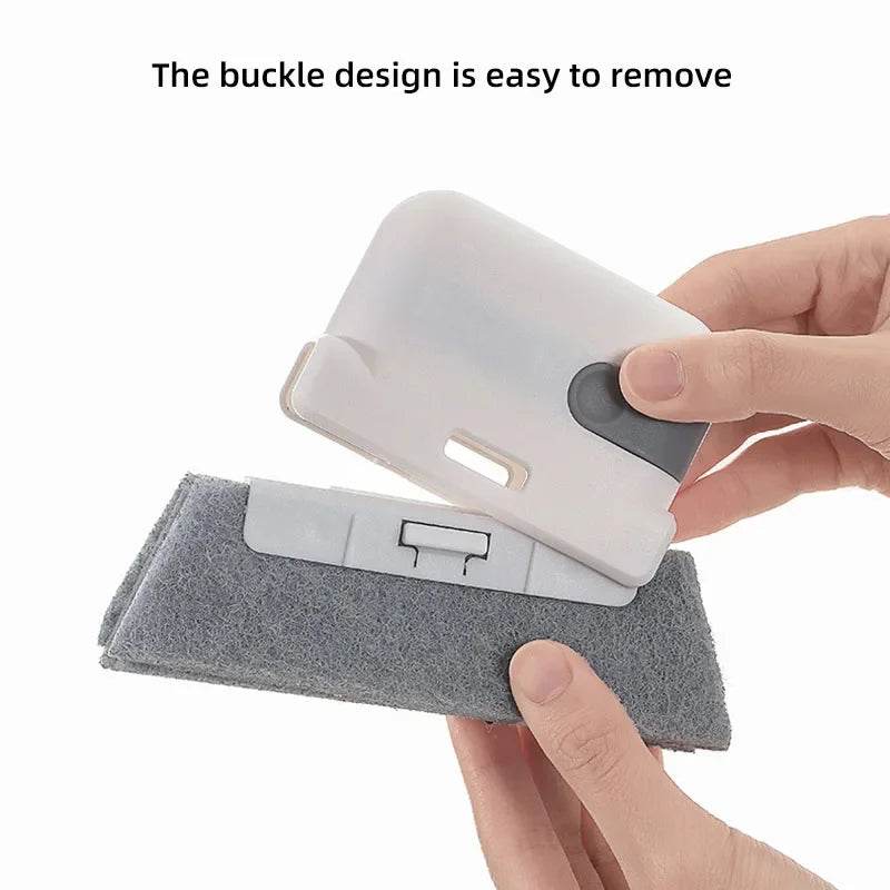 White and gray handheld crevice cleaner with removable buckle design held over gray cleaning pad.
