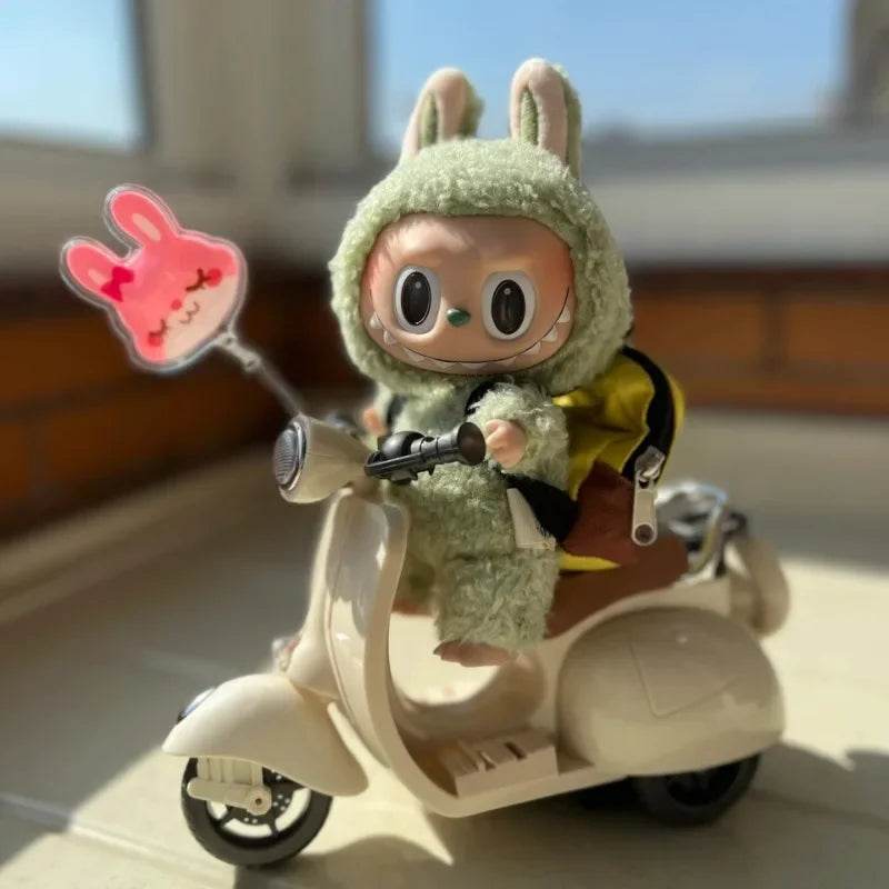 Mini doll in fuzzy green bunny costume riding white vintage-style electric scooter with pink bunny balloon accessory.