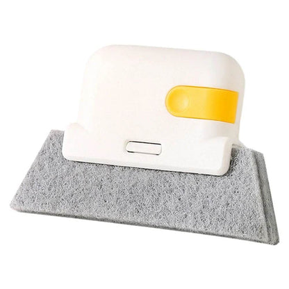 White handheld groove cleaning brush with a wide gray felt pad and yellow sliding button.