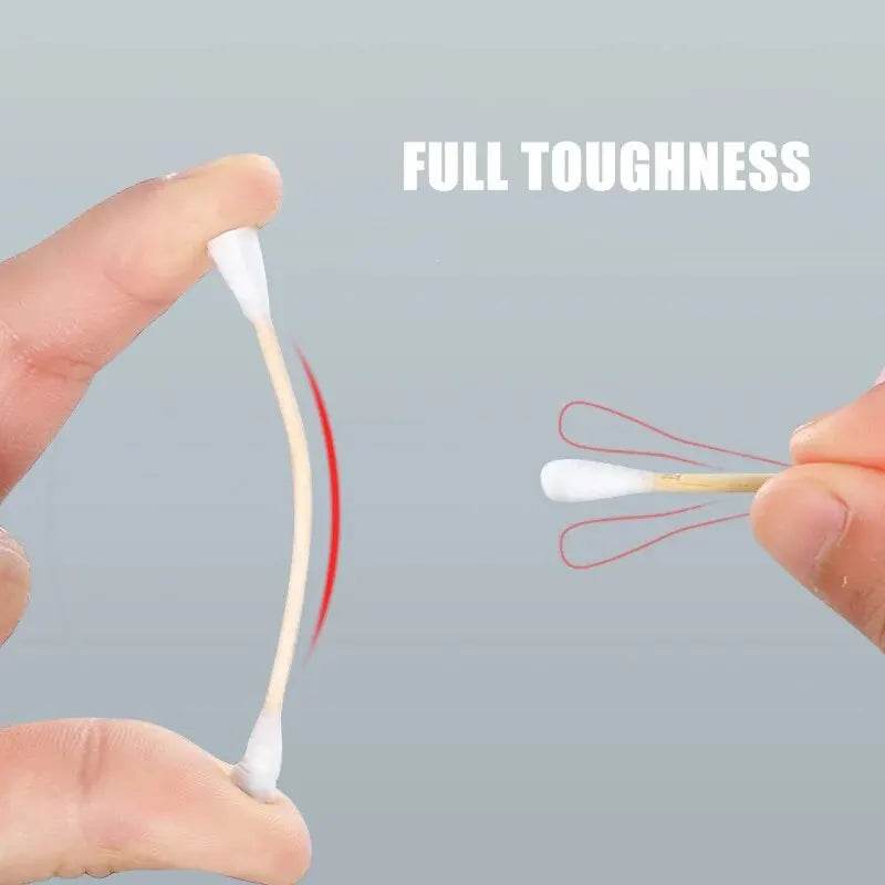 Close-up of flexible double-ended cotton swab with round white cotton tips held between fingers against gray background.