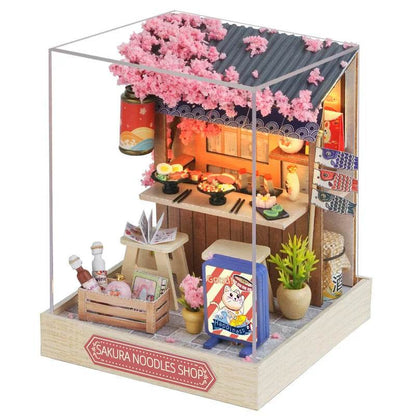 Miniature Sakura Noodles Shop dollhouse with pink cherry blossom roof and interior furniture details.