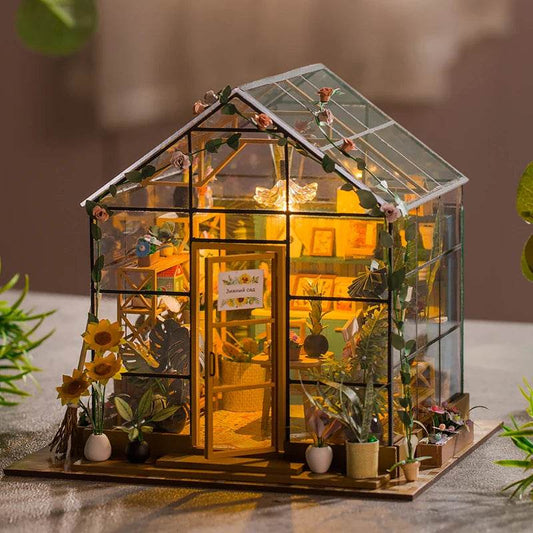 Miniature DIY flower house dollhouse with glass walls, roof, warm interior lighting, and detailed furniture.