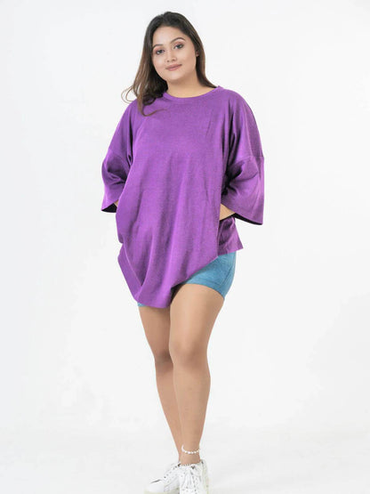 Purple relaxed fit oversized t-shirt with dropped shoulders and side slits, worn with denim shorts.
