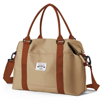 Khaki waterproof duffel bag with brown handles, adjustable shoulder strap, and front patch logo.