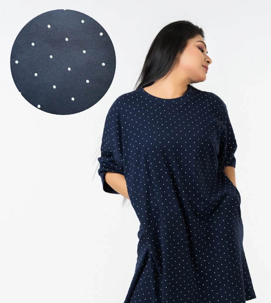 Navy blue relaxed fit t-shirt with small white polka dots, worn with sleeves rolled up.