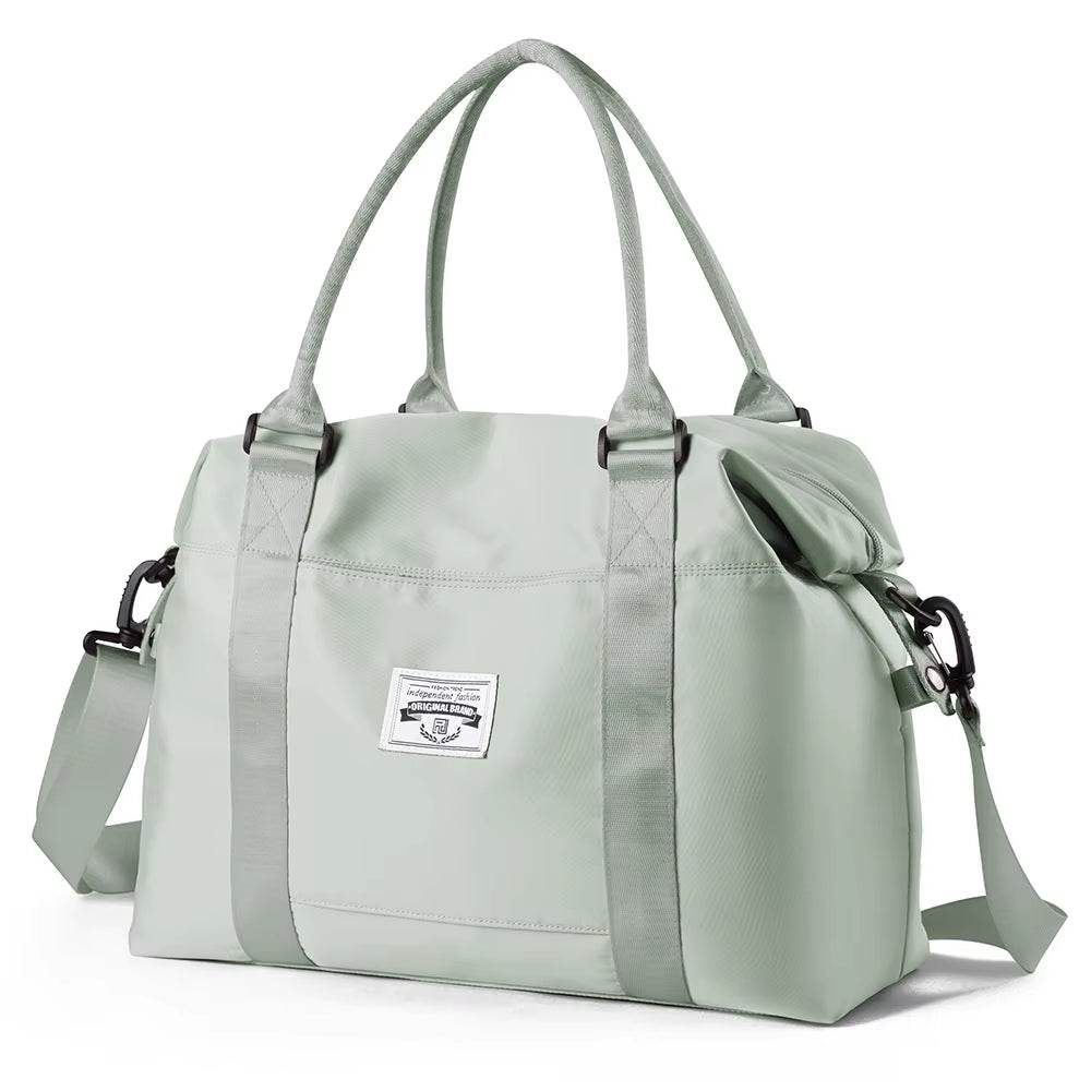 Light gray waterproof duffel bag with dual top handles, detachable shoulder strap, and front logo patch.